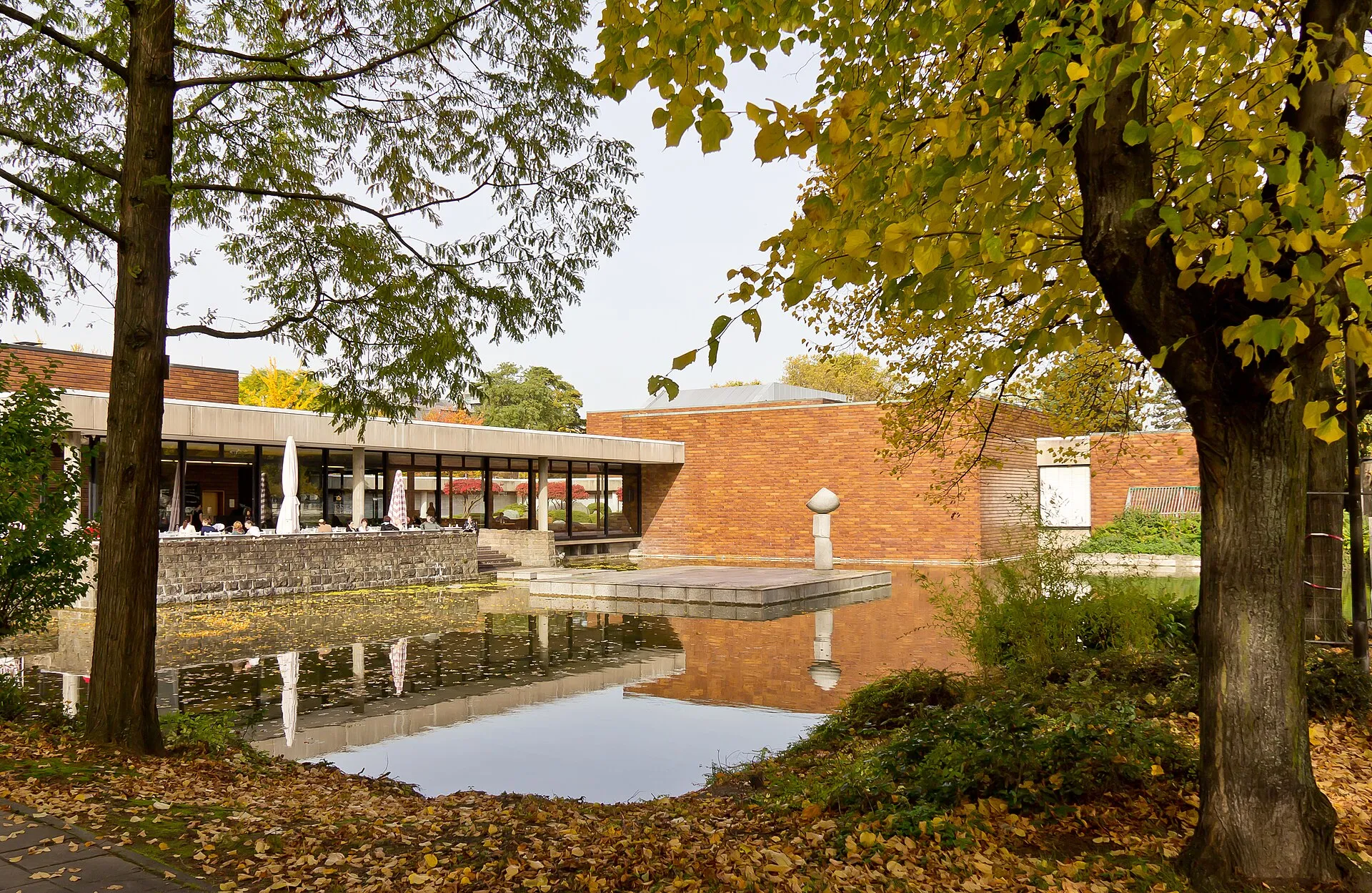 Museum für Ostasiatische Kunst Köln. Ansicht von Südosten mit dem Aachener Weiher und der Plastik „Fahne im Wind“ von Masayuki Nagare