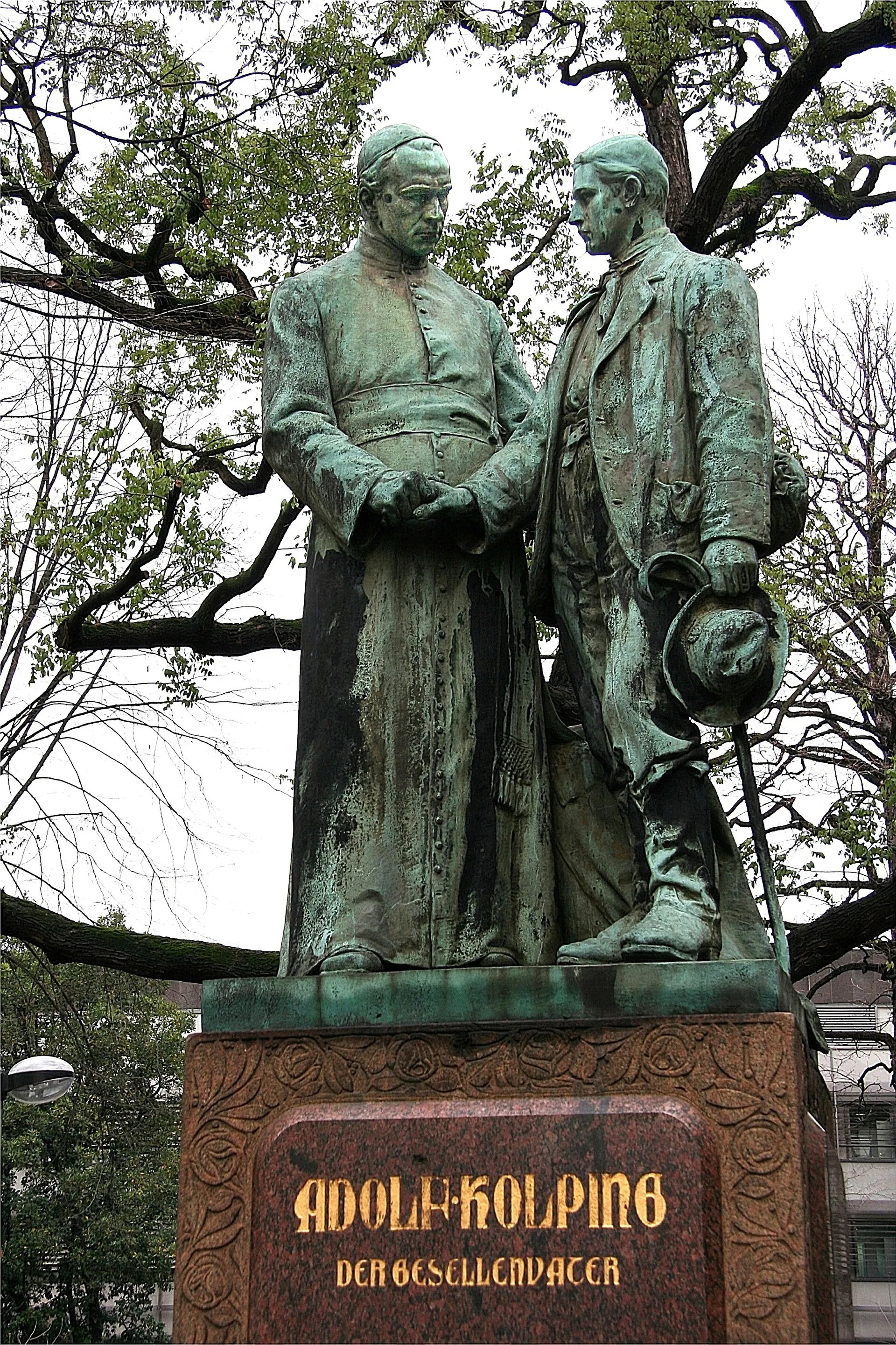 Kolping-Denkmal in Köln von Joh. L. Schreiner, München, 1903. Das Denkmal zeigt den „Gesellenvater“ Kolping mit einem Wanderburschen.