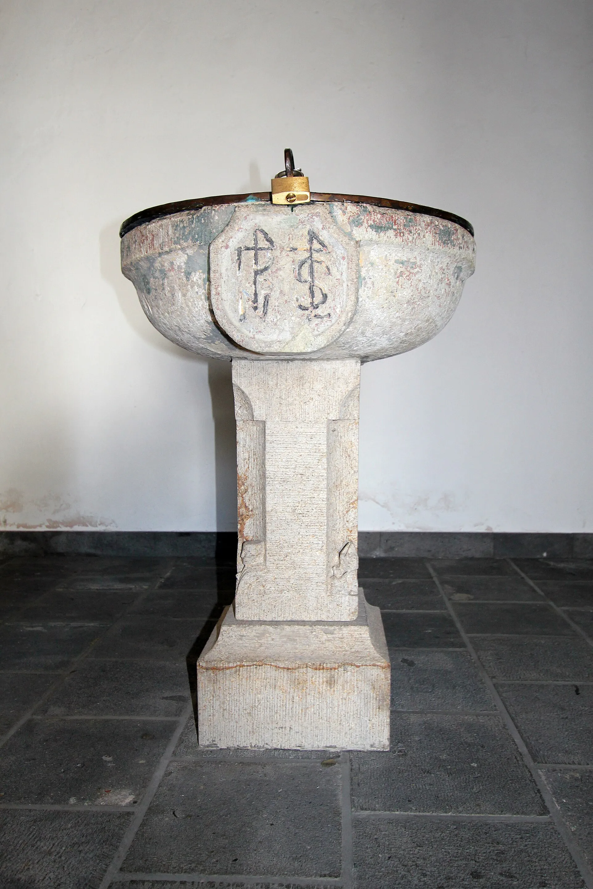 Alt Sankt Maternus Köln-Rodenkirchen. Gothischer Taufstein 1,15 x o,65 m. Einfaches kreisrunders Becken, an dessen Vorderseite ein Schild mit Hausmarken die Buc