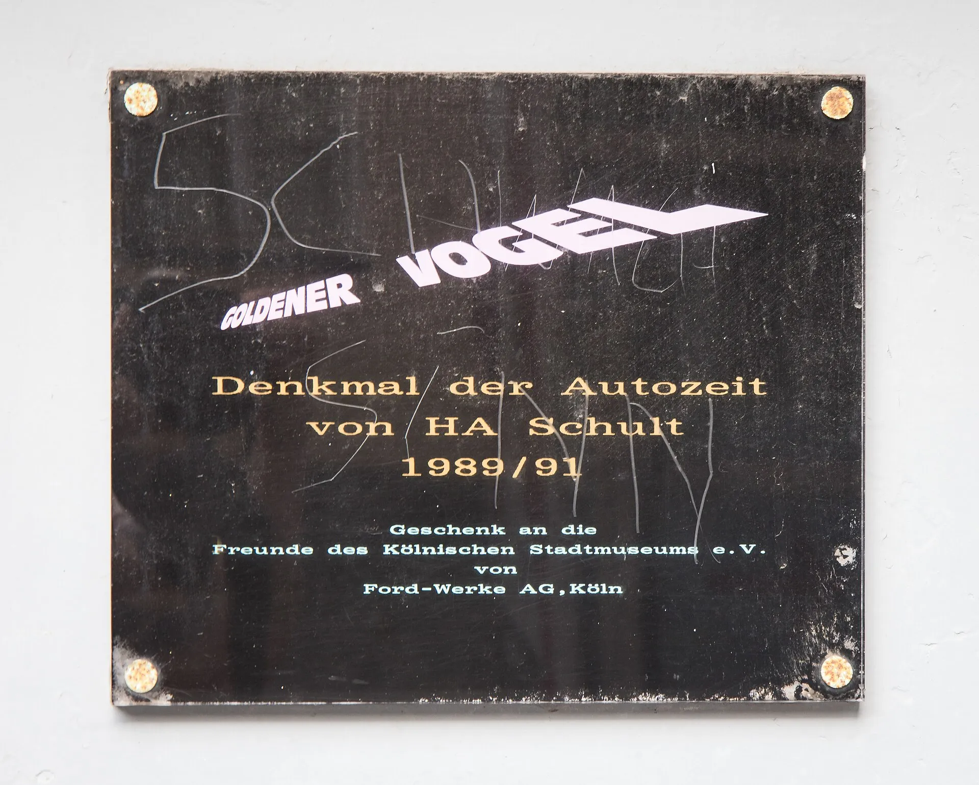 Schild am Zeugaus – Goldener Vogel von HA Schult 1989/1991, Geschenk an die Freunde des Kölnischen Stadtmuseums e.V. von Ford-Werke AG, Köln