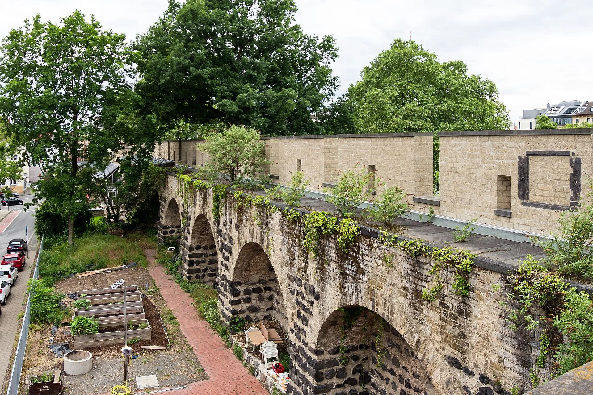 Gereonsmühle Köln mit Stadtmauer. Blick vom Mühlengang auf die Stadtmauer mit rundbogigen Blendarkaden stadtseitig (rechts) und den Garten
