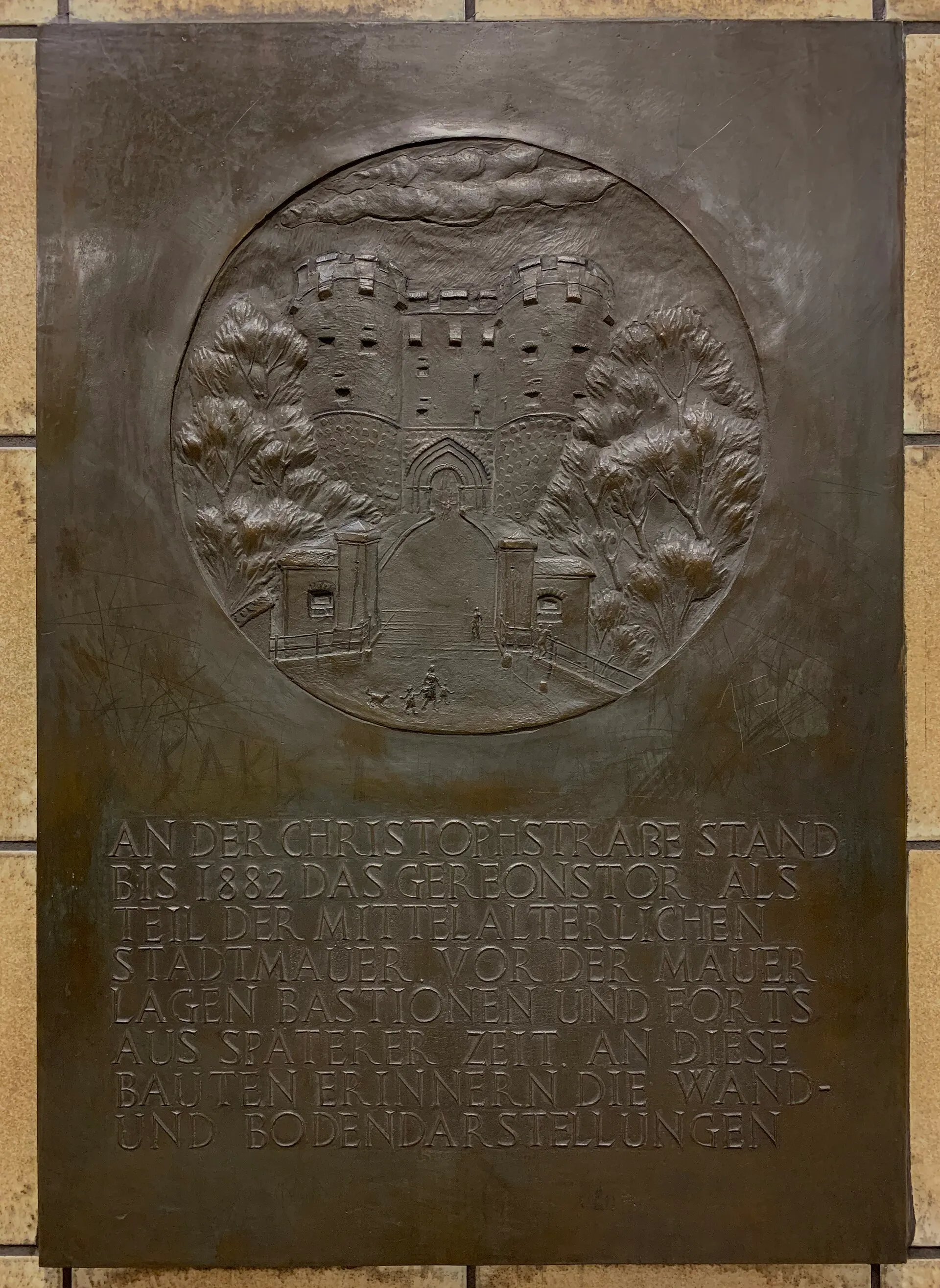 Bronzetafel im U-Bahnhof Christophstraße/Mediapark in Köln. Text: AN DER CHRISTOPHSTRASSE STAND BIS 1882 DAS GEREONSTOR ALS TEIL DER MITTELALTERLICHEN STADTMAUE