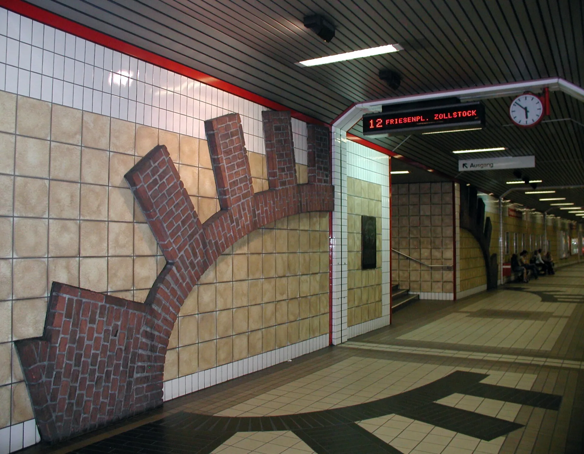 Köln, U-Station Christophstraße, Gedenktafel neben stilisierter Darstellung des mittelalterlichen Stadtmauertores Gereon.