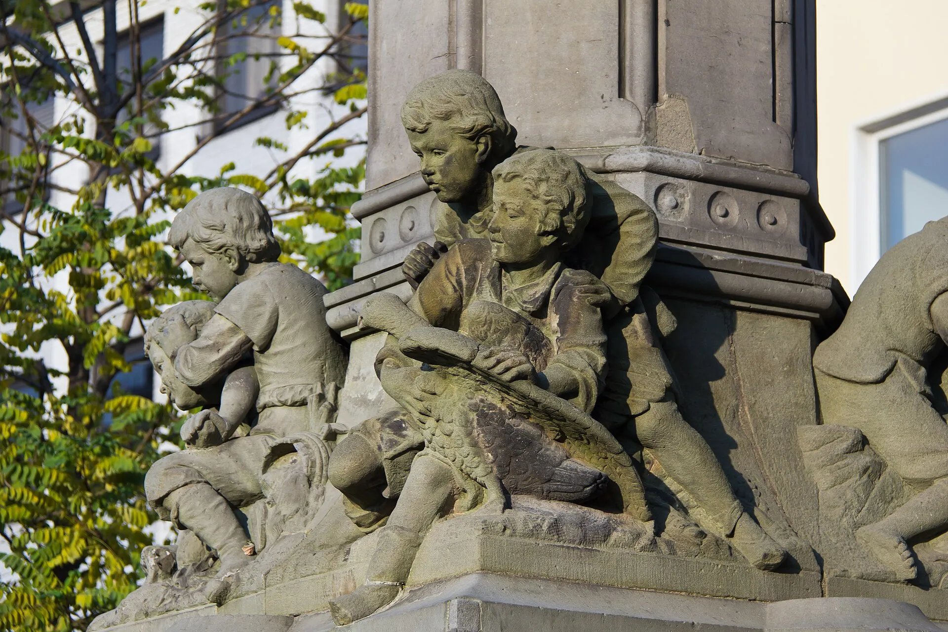 Hermann-Joseph-Brunnen, Waidmarkt, Köln. Detail: Sich raufende Knaben am Sockel der Säule