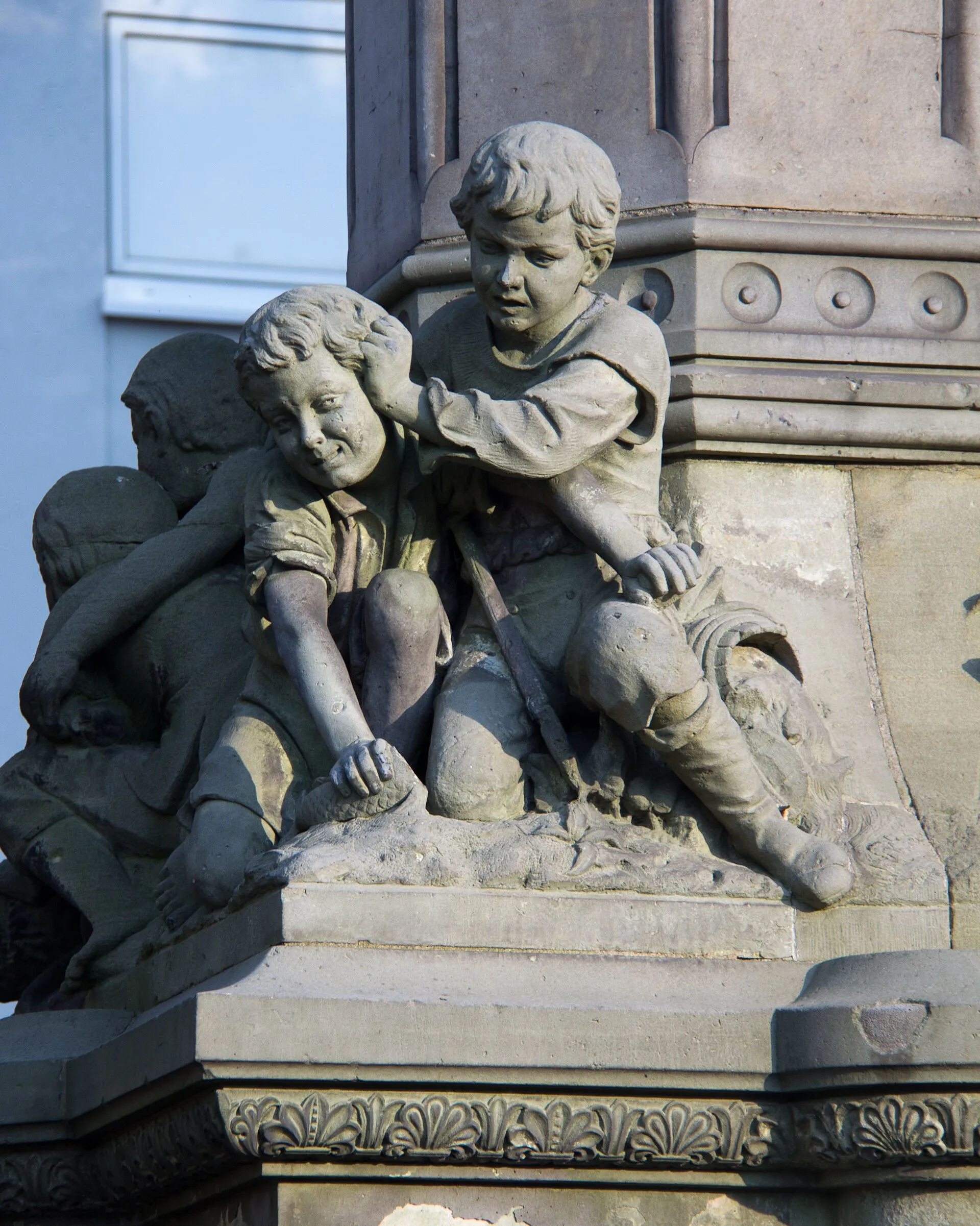Hermann-Joseph-Brunnen, Waidmarkt, Köln. Detail: Sich raufende Knaben am Sockel der Säule