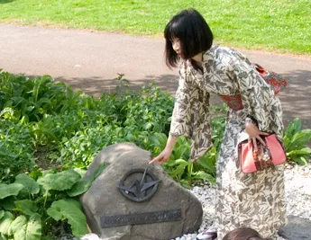 Die Künstlerin Yoshie Shibahara erklärt auf der interkulturellen Wanderung wieso der Origami-Kranich auf dem Anti Atom Denkmal des Kölner Bündnisses gegen Atomk