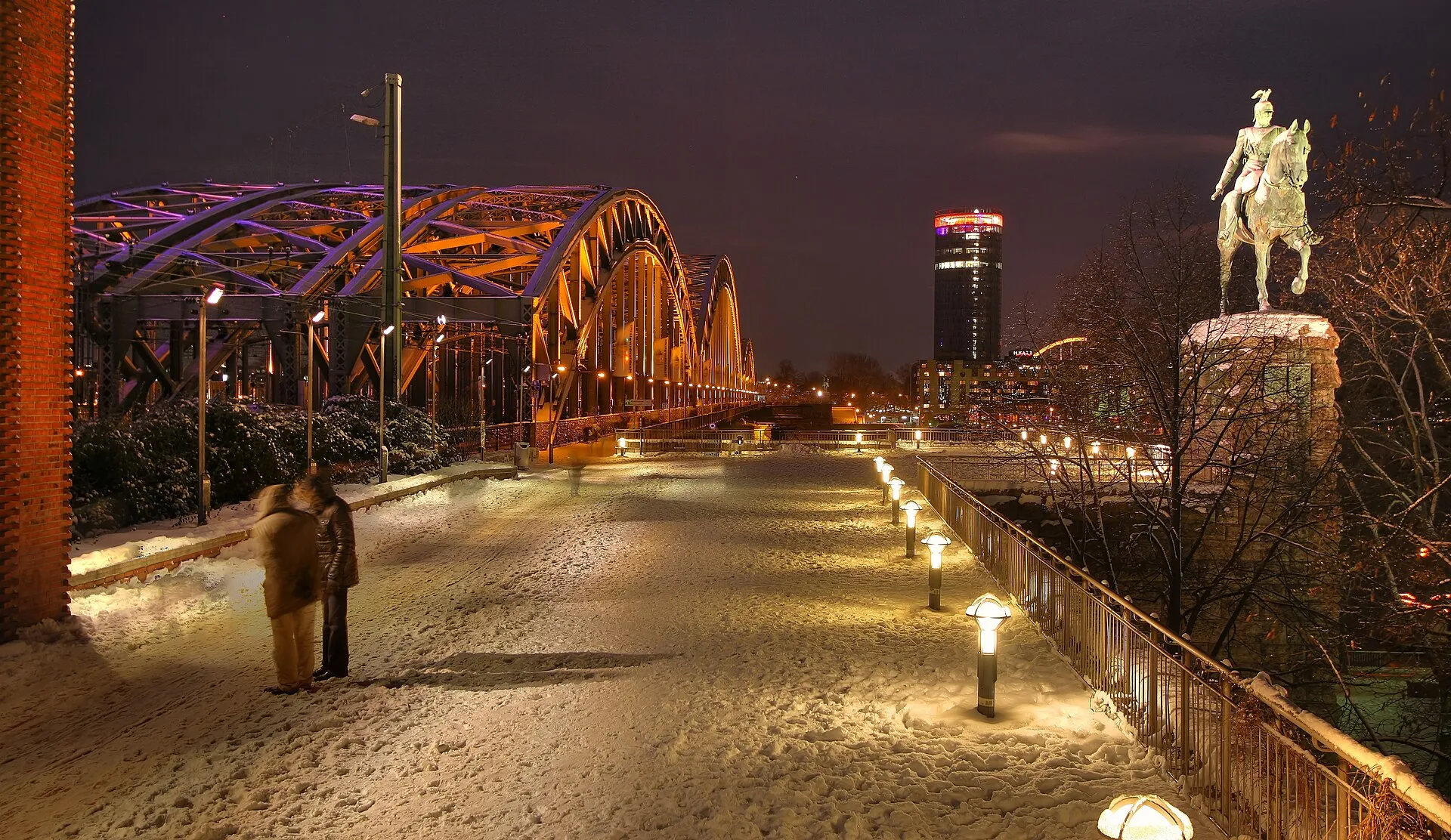 Hohenzollernbrücke, KölnTriangle und das Reiterstandbild Wilhelm II. in einer Winternacht nach Schnellfall