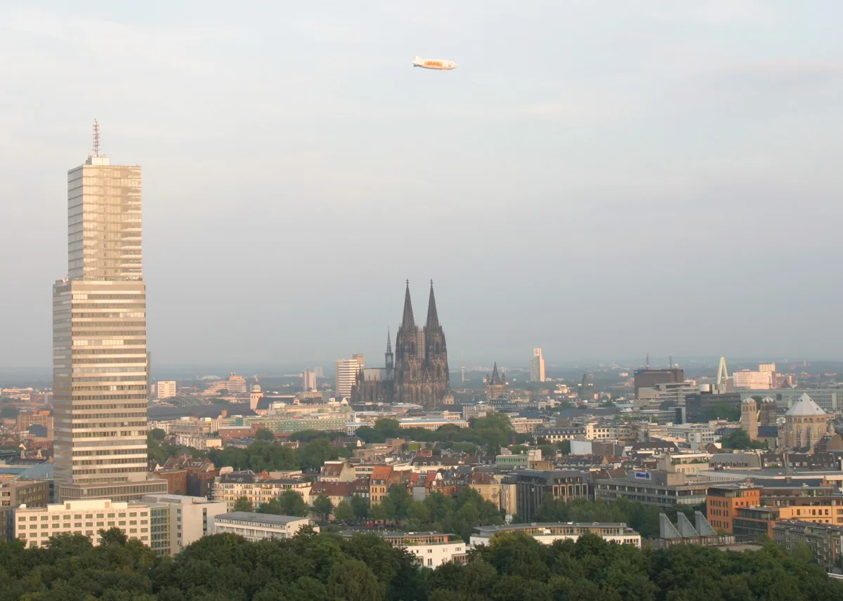 A view of the Cologne inner city, including the Dom , the Kölnturm and a Zeppelin NT over the city (on August 18th,2005) because the Pope was in Cologne on that