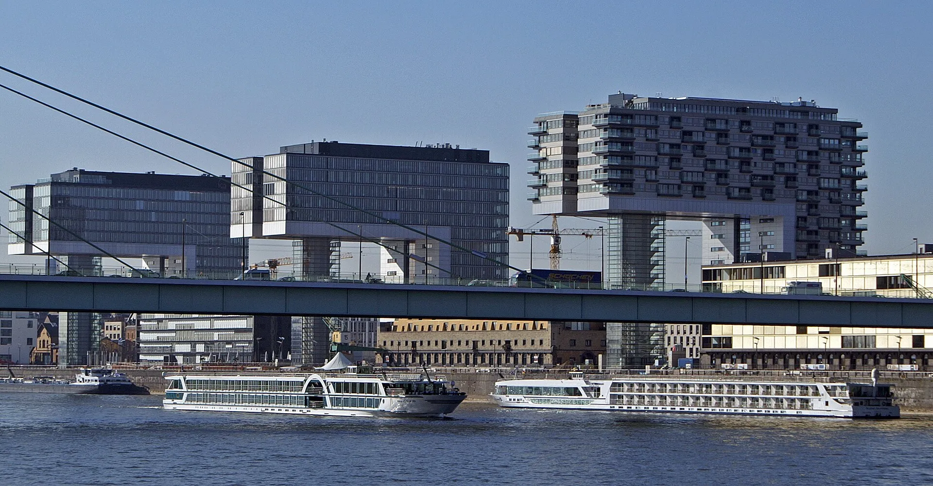 Flusskreuzfahrtschiff Amadeus Diamond auf Fahrt unterhalb der Severinsbrücke in Köln. Im Hintergrund die drei Kranhäuser im Rheinauhafen.