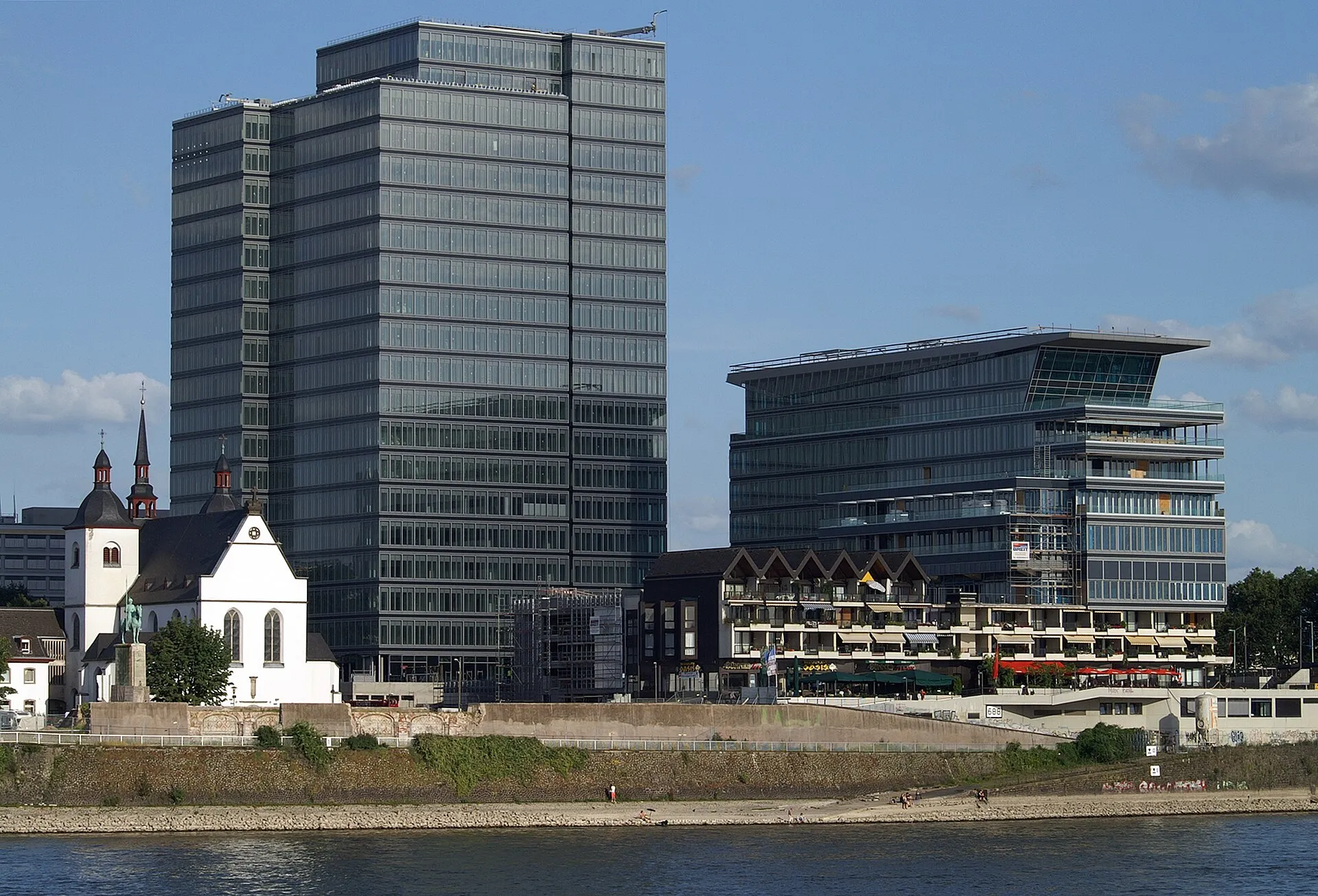 Das im Bau befindliche MaxCologne (LanxessTower) ohne Baukrane und mit geschlossener Fassade — links daneben Alt St. Heribert.