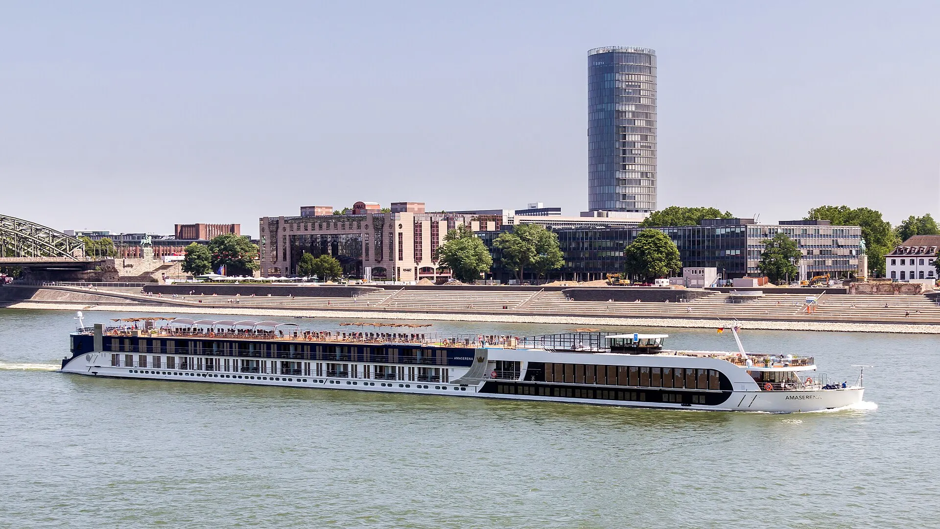 Das Flusskreuzfahrtschiff Amaserena (ENI: 07002014) der Schweizer Reederei Ama Waterways auf dem Rhein in Köln. Im Hintergrund das Ufer von Deutz mit der neuen