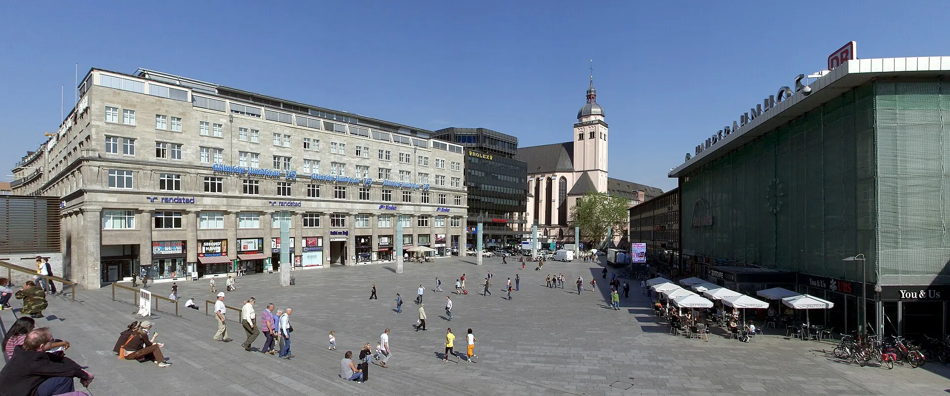 Bahnhofsvorplatz: Links das Deichmannhaus, Mitte St. Mariä Himmelfahrt (Köln) , rechts die Haupthalle des Kölner Hauptbahnhofs