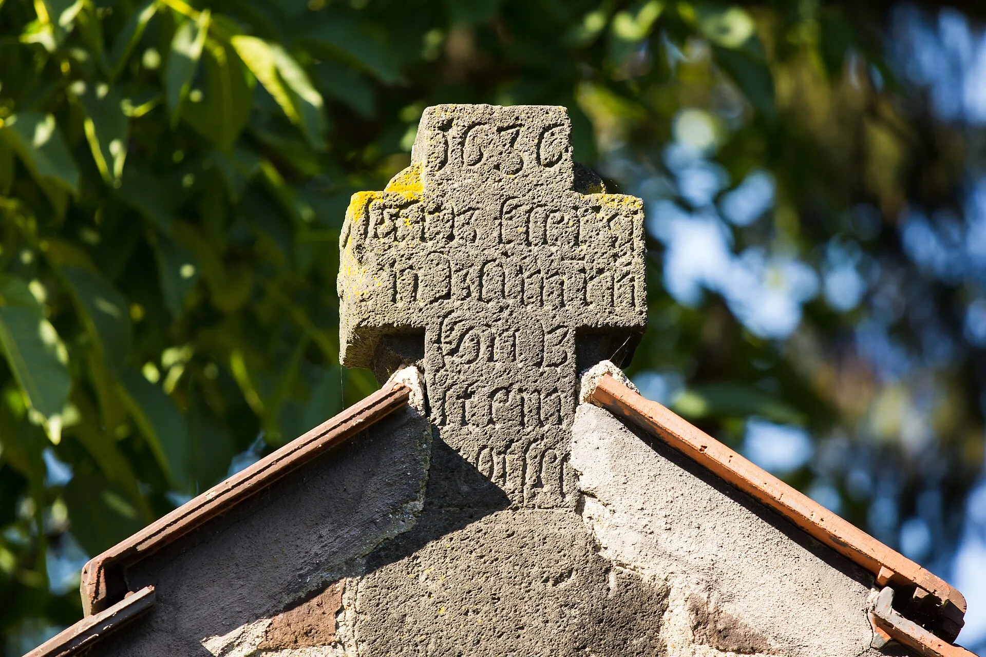 Katholische Pfarrkirche St. Servatius in Köln-Immendorf. Steinkreuz im Giebel eines Totenhäuschens