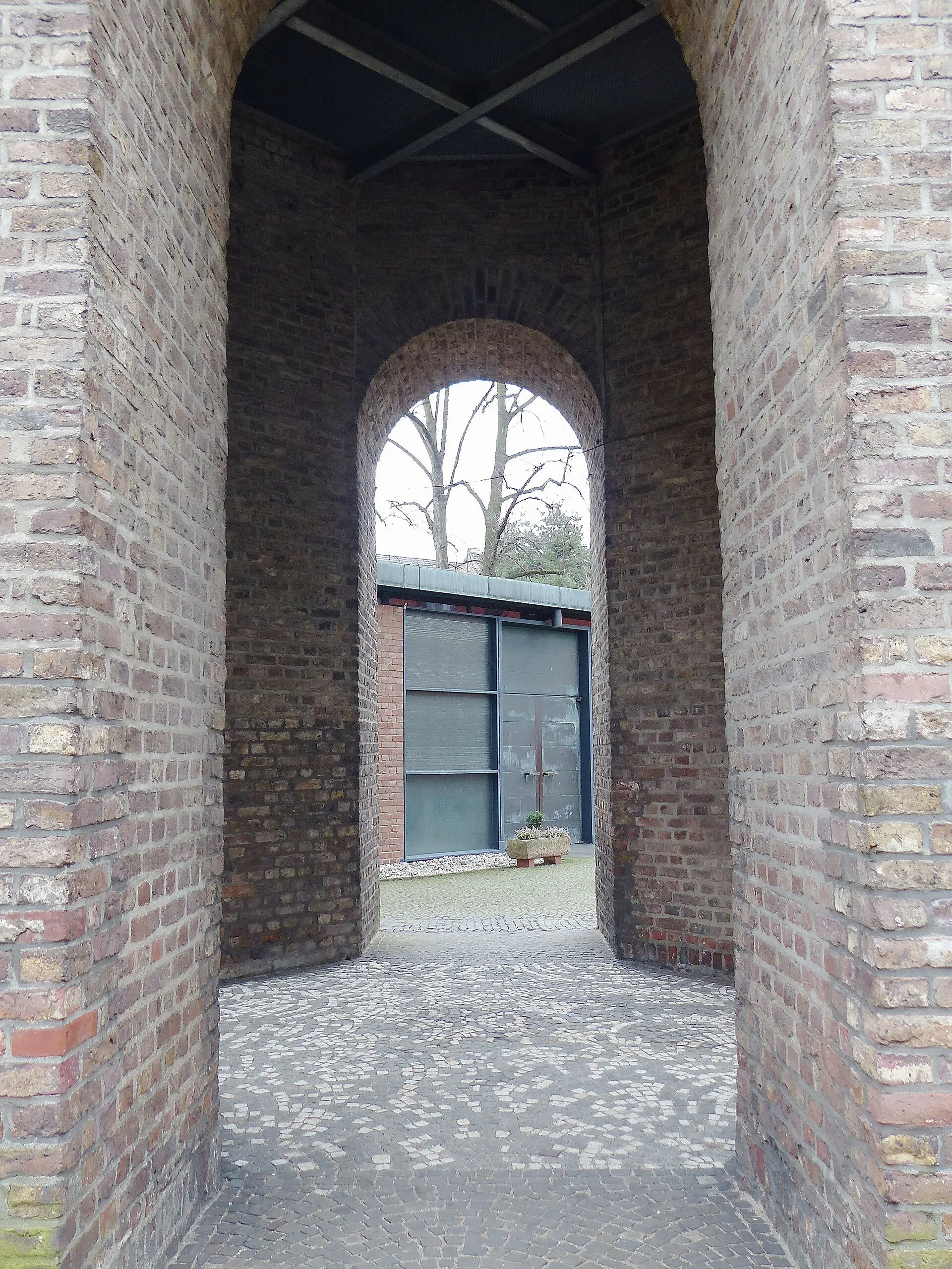 Blick auf den Eingang zum Gemeindesaal von St. Stephan in Köln-Lindenthal. Im Vordergrund die Campanile
