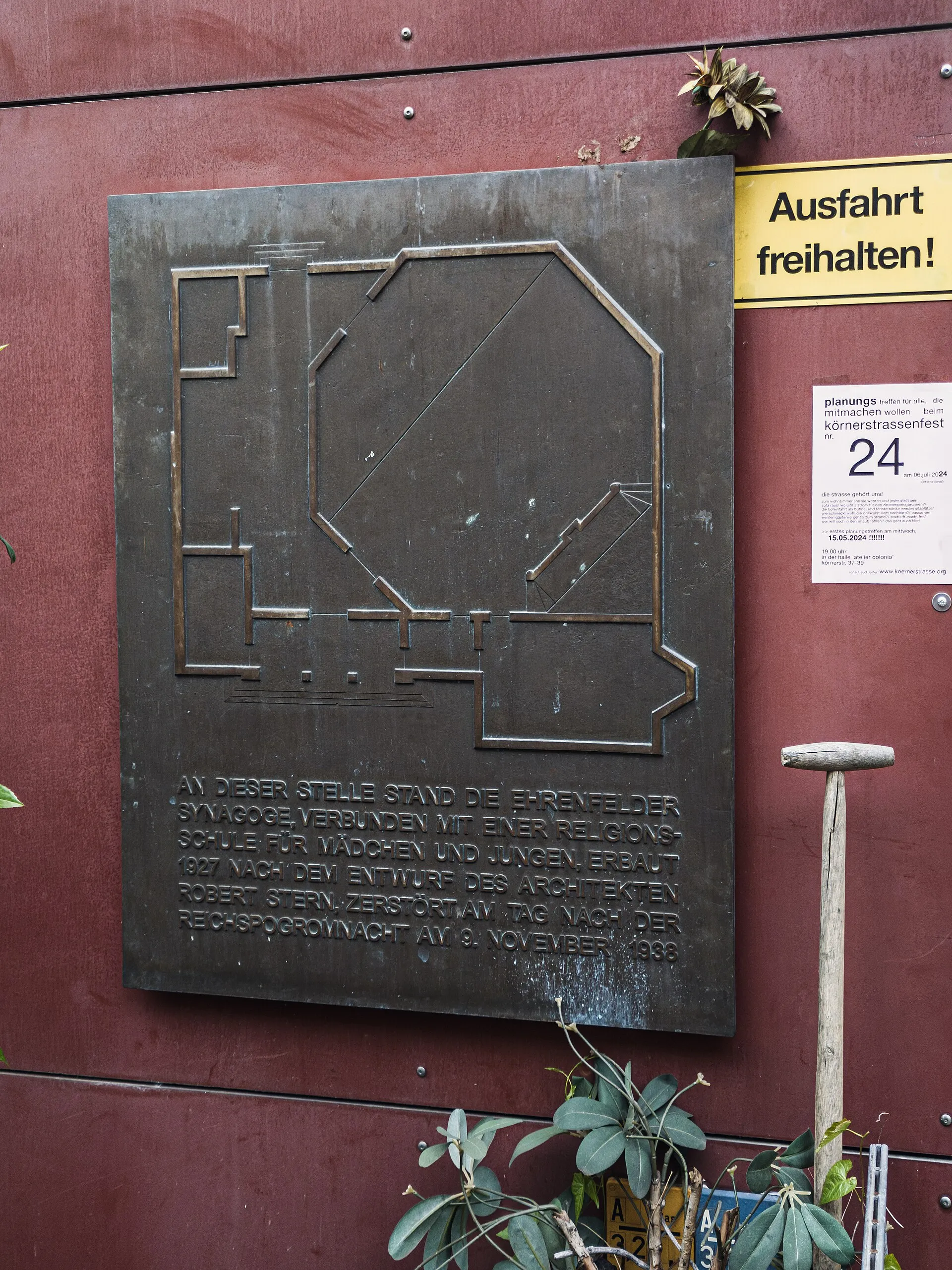 Gedenktafel am Ort der Synagoge Körnerstraße, Köln Ehrenfeld. Situation April 2024. Inschrift: An dieser Stelle stand die Ehrenfelder Synagoge, verbunden mit ei