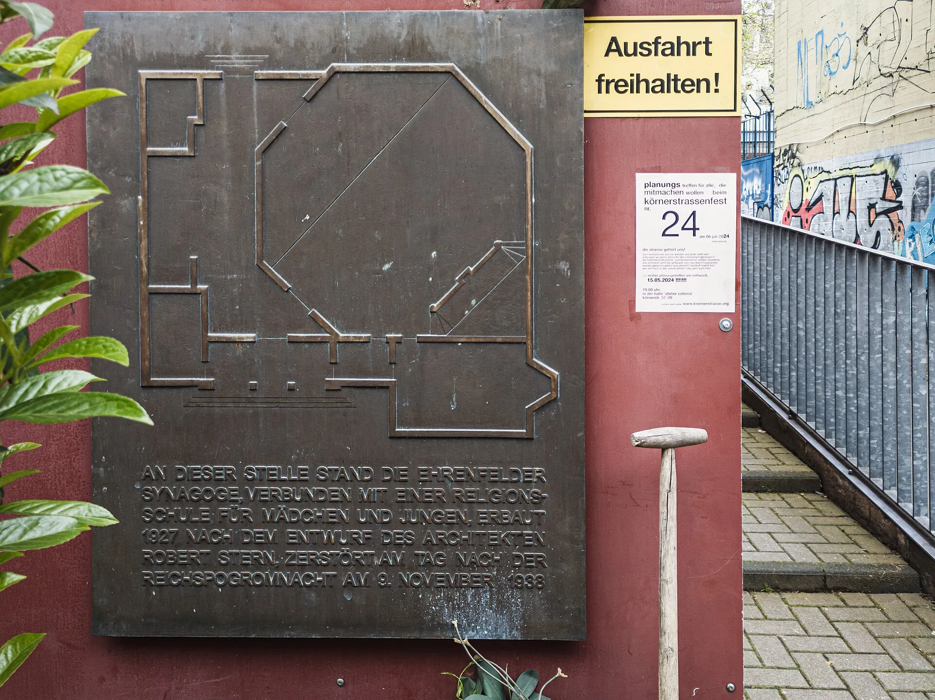 Gedenktafel am Ort der Synagoge Körnerstraße, Köln Ehrenfeld. Situation April 2024. Inschrift: An dieser Stelle stand die Ehrenfelder Synagoge, verbunden mit ei