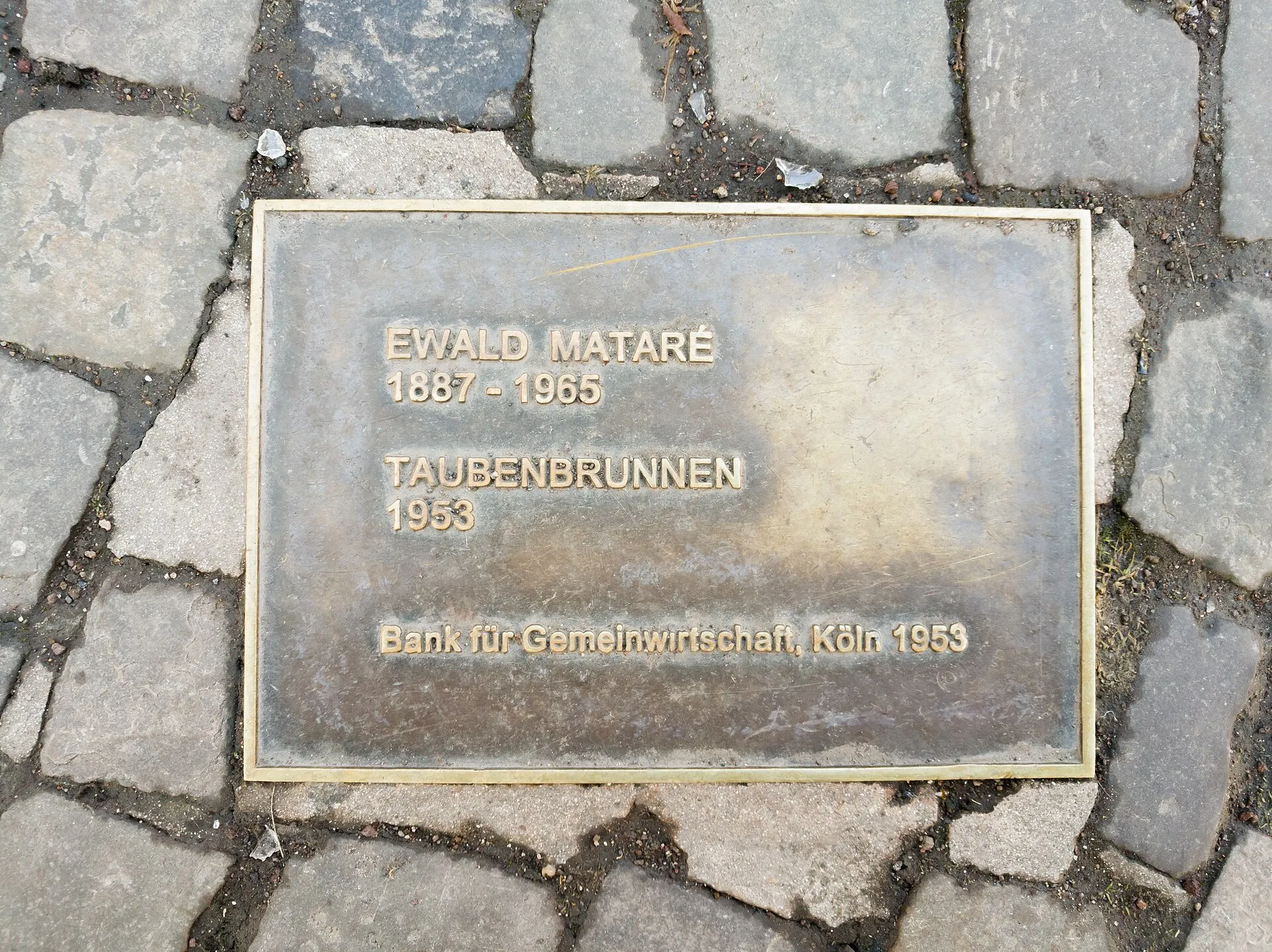 Pigeon fountain, Cologne. description with name of the artist, the work and the sponsor, a bank.