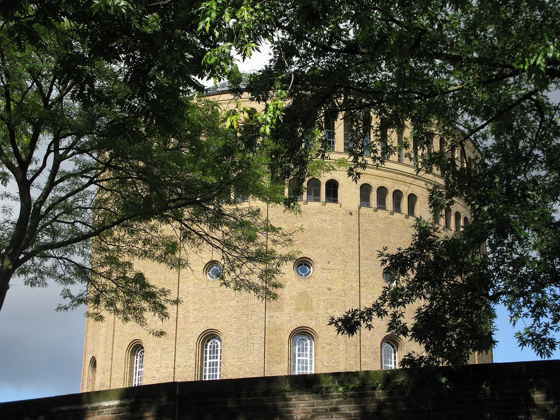 Blick durch Bäume auf das Hotel Wasserturm